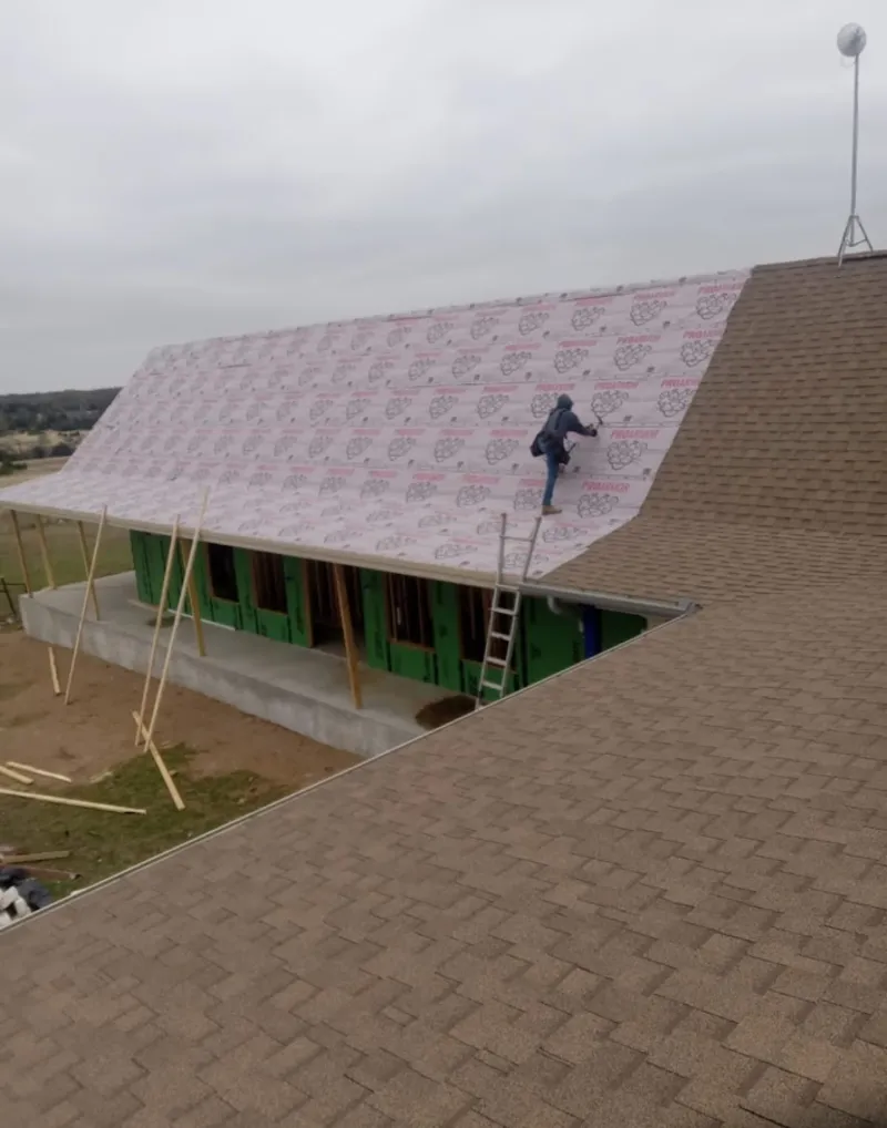 Worker preparing underlayment for a metal roof installation in Broadlands